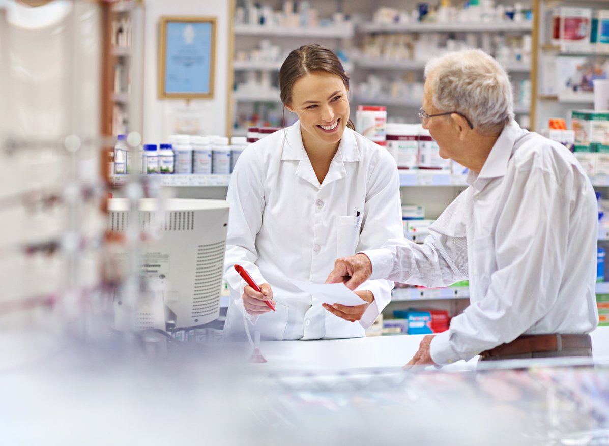 female pharmacist talking to elderly male patient