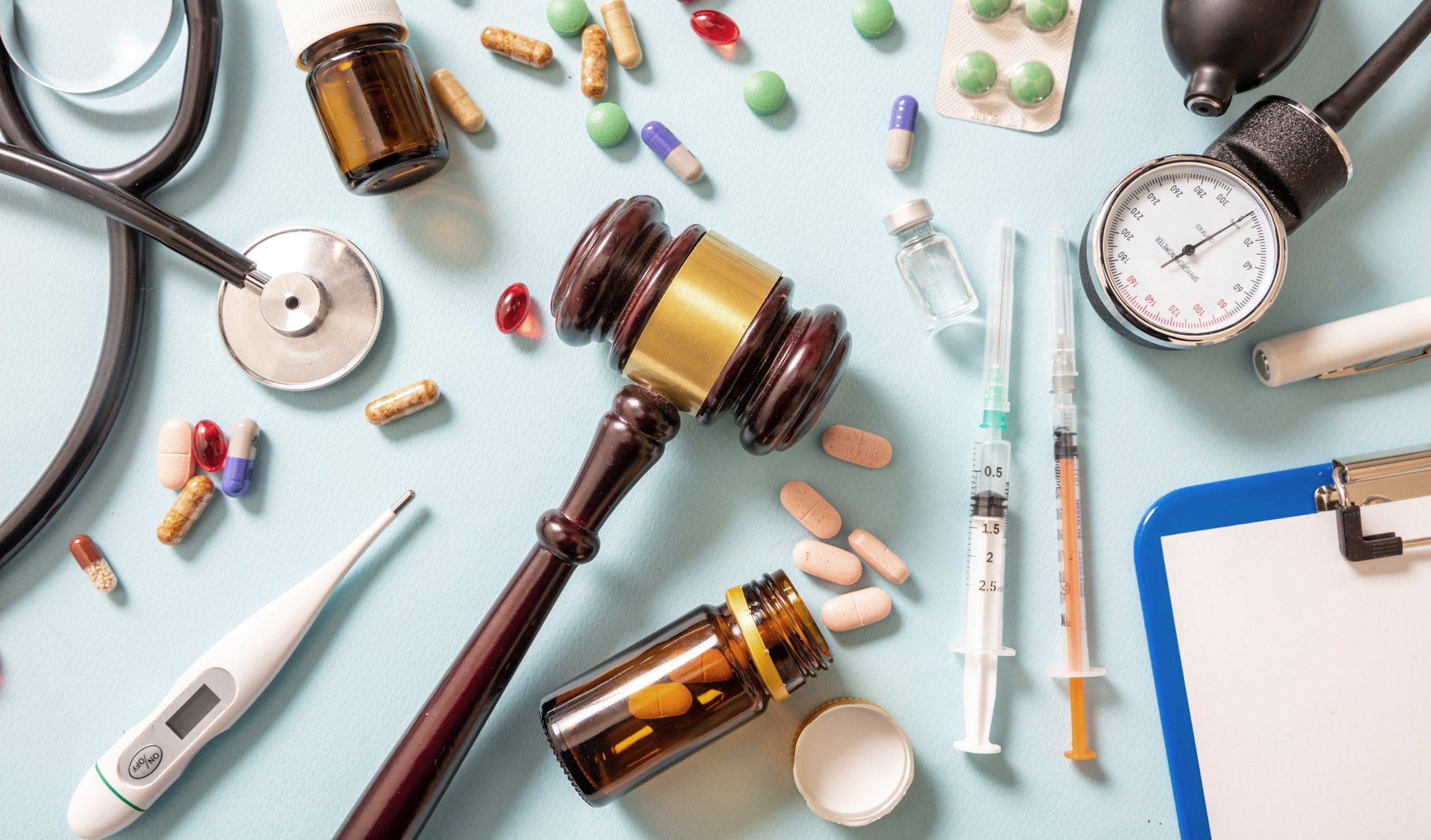 pills and healthcare items laying next to judge gavel